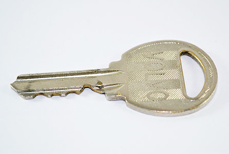 brass-colored Volvo key on white surface thumbnail