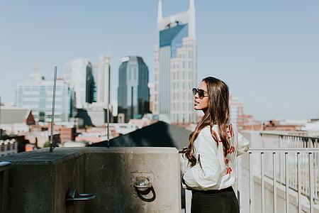 woman standing near white metal fence thumbnail