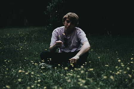 man sitting on green grass field thumbnail