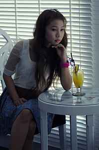 woman wearing white dress sitting on chair while putting her arm on table thumbnail