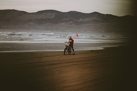 ma riding on motorcycle near body of water thumbnail