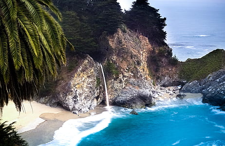 seashore near rock cliffs and tress thumbnail