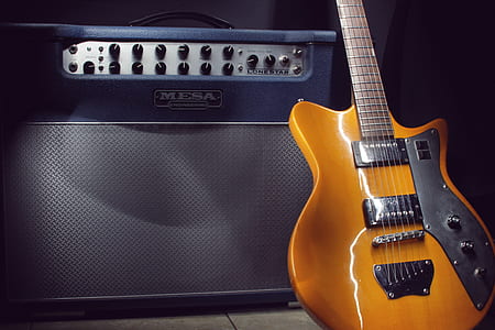 Brown Electric Guitar Beside Black Guitar Amplifier thumbnail