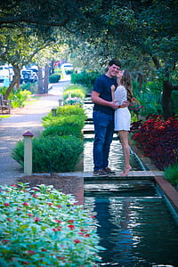 Woman and Man Standing on Bridge Kissing thumbnail