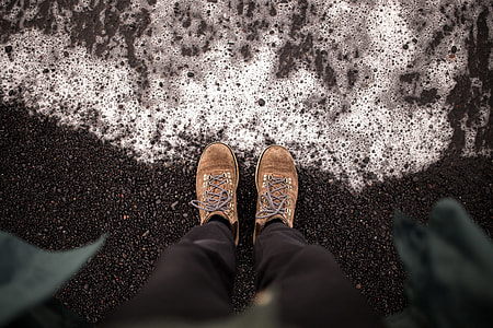 person wearing brown shoes and black pants standing on black asphalt road thumbnail