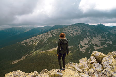 woman in black jacket and leggings standing on beige cliff during daytime thumbnail