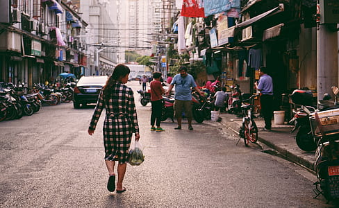 woman carrying plastic bag while walking on street thumbnail