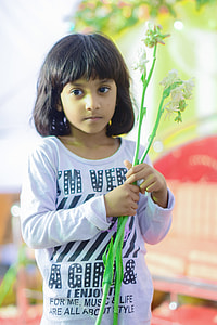 girl holding white petaled flowers thumbnail
