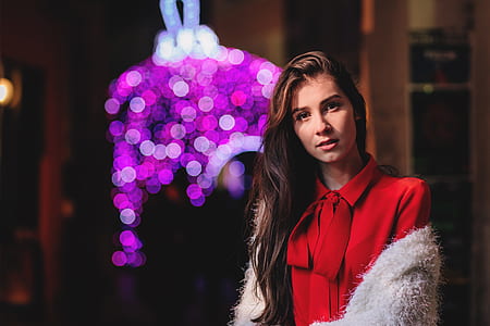 selective focus photography of woman wearing red button-up top with bow accent thumbnail