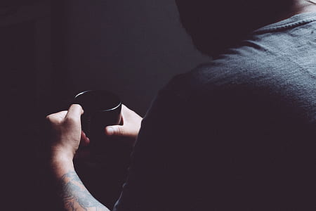 man holding black ceramic coffee mug thumbnail
