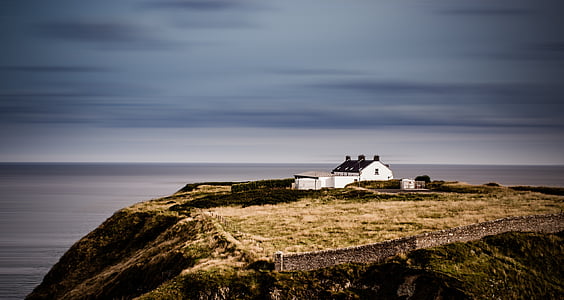 white concrete house on top of hill under gray sky at daytime thumbnail