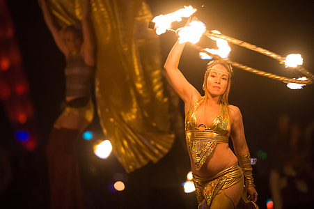 shallow focus photography of gold bikini set holding burning hula hoop thumbnail