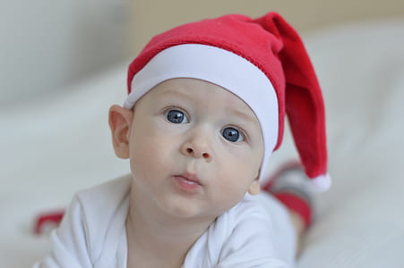 boy wearing white shirt and red Santa hat thumbnail