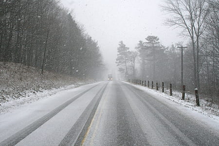 vehicle travelling on road during winter thumbnail