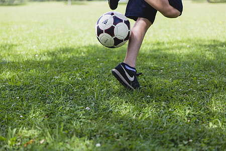 person playing soccer on grass field thumbnail