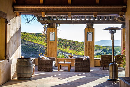 grey stainless steel patio heater near two wicker sofas and brown wooden barrel thumbnail