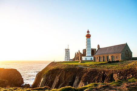 lighthouse near body of water during daytime thumbnail