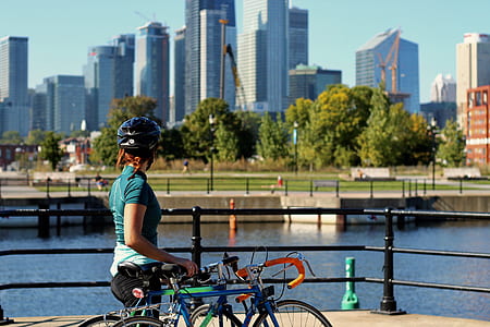 woman holding teal road bike standing near body of water thumbnail