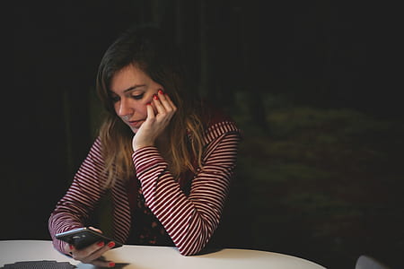woman's elbow leaning on table holding phone thumbnail