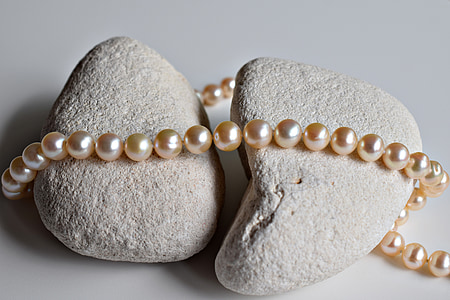 white pearl necklace on gray rocks thumbnail