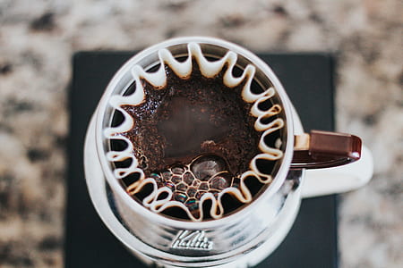 white and brown ceramic cup filled with coffee thumbnail