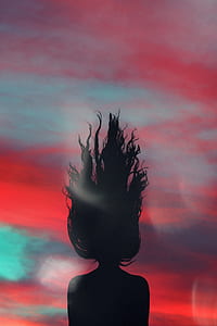 silhouette of woman under blue and red sky thumbnail