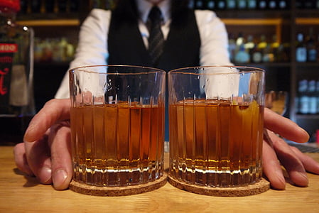 person holding two drinking glasses thumbnail