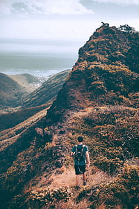 person walking toward hill during dayitme thumbnail