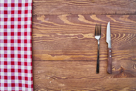 gray stainless fork butter knife on brown wooden surface thumbnail