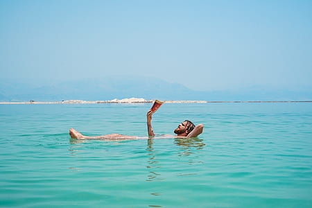 man swimming on body of water thumbnail