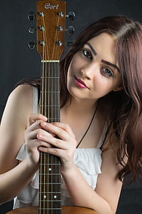 woman holding brown acoustic guitar thumbnail