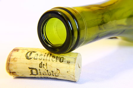 green glass bottle on cork on white surface thumbnail