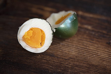 selective focus photography of sliced boiled egg on brown wooden surface thumbnail