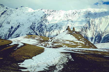 white and blue snow covered high mountain under cloudy sky at day time thumbnail