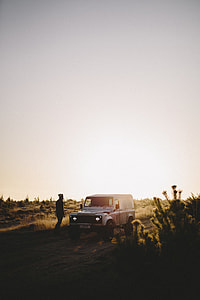 man stands beside white SUV at the desert thumbnail
