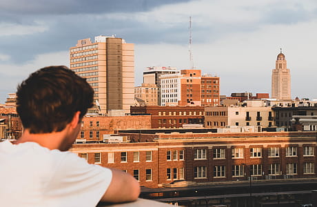 Boy in White Crew-neck T-shirt Looking on Building thumbnail