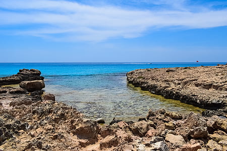 rock formation near body of water at daytime thumbnail
