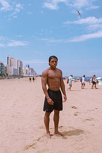 Man Standing On Seashore Under Blue Sky thumbnail