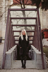 Woman in Black Coat Standing Near Staircase thumbnail
