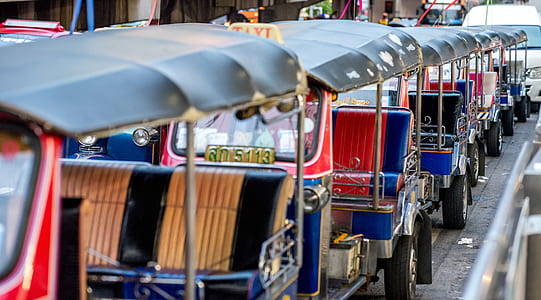 assorted-color auto-rickshaws lined up thumbnail