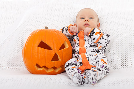 baby boy wearing white and orange footie pajama beside jack o lantern thumbnail