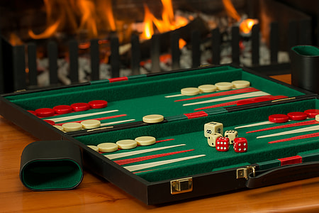 green, red, and white backgammon board on brown wooden tabletop thumbnail