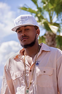 man wearing brown dress shirt and white fitted cap thumbnail