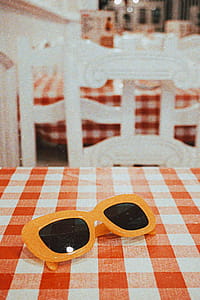 Sunglasses With Orange Frames on Checkered Tablecloth thumbnail