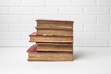 several red hard bind books on white surface thumbnail