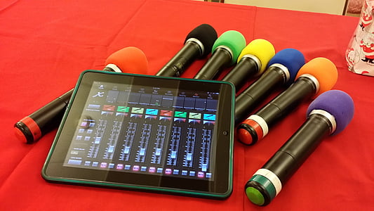 assorted-color microphones and black iPad on red textile thumbnail
