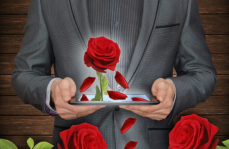 man in black formal suit jacket holding table computer with 3D rose digital wallpaper thumbnail