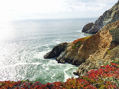 rocky cliff near body of water during daytime thumbnail