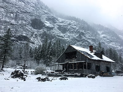 wooden house under snowfield beside mountain thumbnail