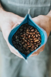 person holding pack of coffee beans thumbnail